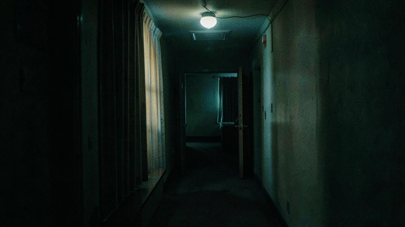 A dim hotel corridor at night.